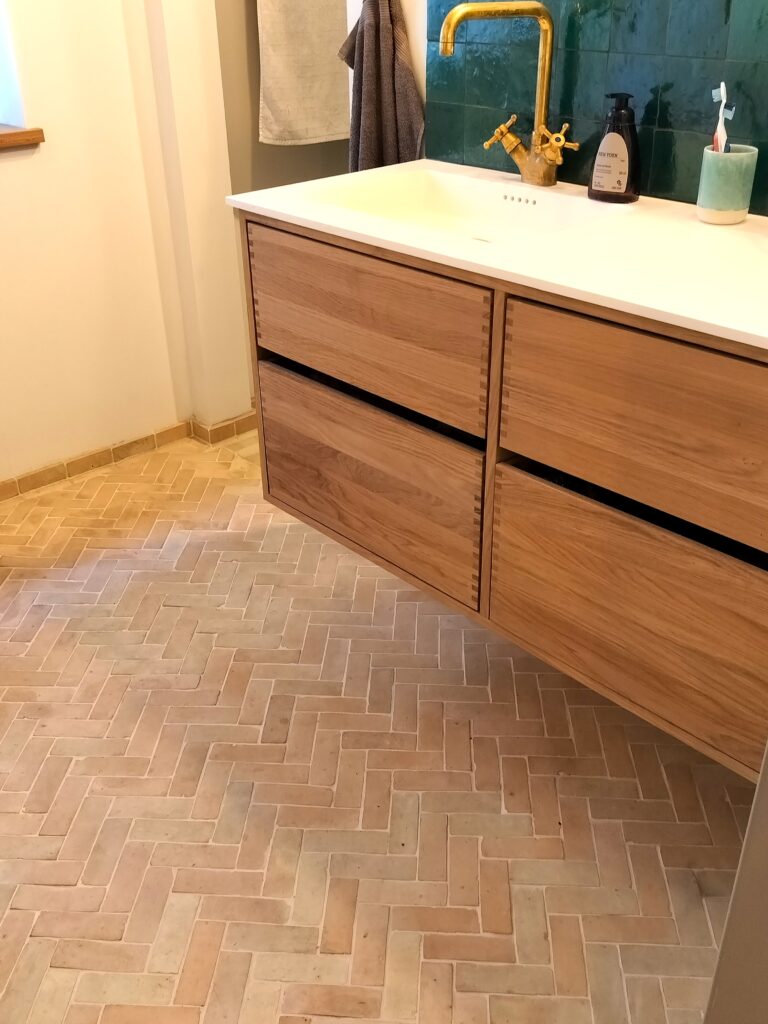 Authentic handmade unglazed Bejmat tiles in natural terracotta. Rustic 4,5x14 cm tiles from Fez, Morocco – timeless warmth with unique artisan texture.