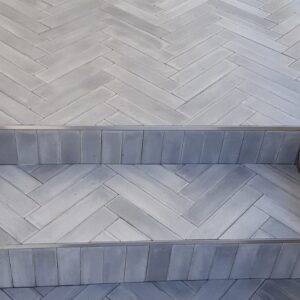 This handmade encaustic cement tile in contemporary style brings timeless elegance to your interior. A herringbone shape in Nordic colors.