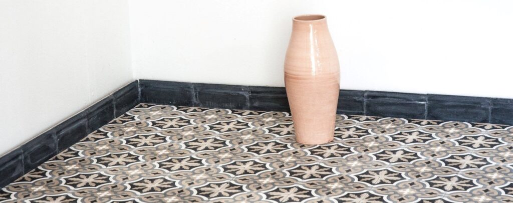 Discover handmade plinth tiles in marble-cement — elegant waved tiles for seamless floor to wall transitions, crafted in a timeless shape.